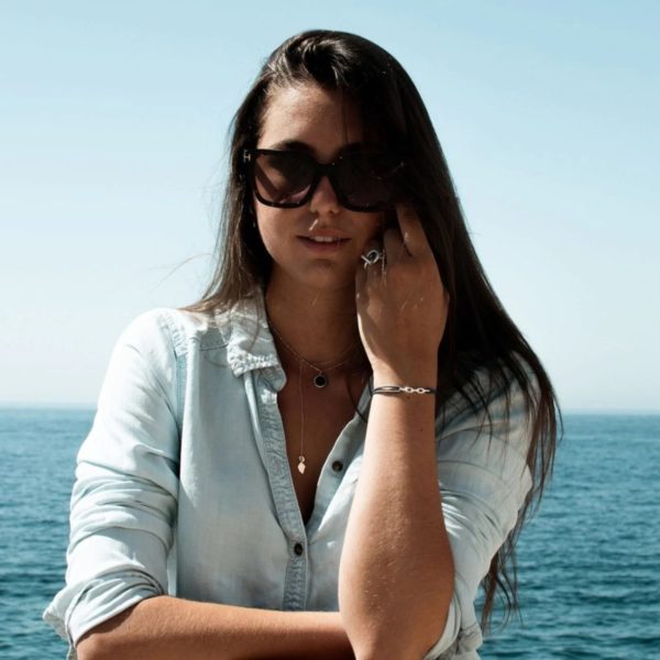 bracelet femme Maille porté par une femme en chemise jean manches retroussées et lunettes de soleil sur fond de mer