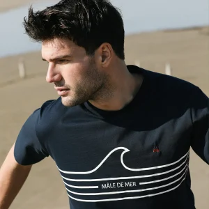 Photo portée, cadrée serré du t-shirt "MÂLE DE MER" sur fond de plage