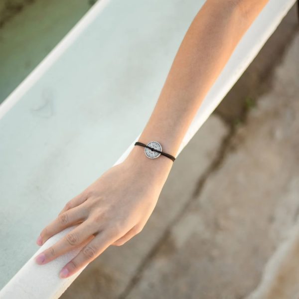 Photo d'un bras portant le bracelet argent vieilli AUSTRAL appuyé sur une rembarde