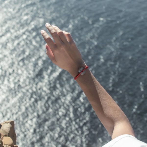 Photo d'un avant bras de femme portant le bracelet SIROCCO sur fond de mer