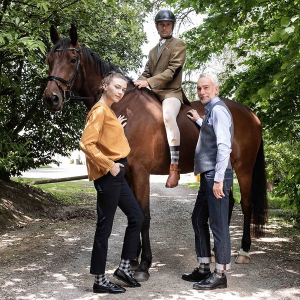 Photo représentant un couple portant les chaussettes TARTAN au pied d'un cheval monté par un cavalier